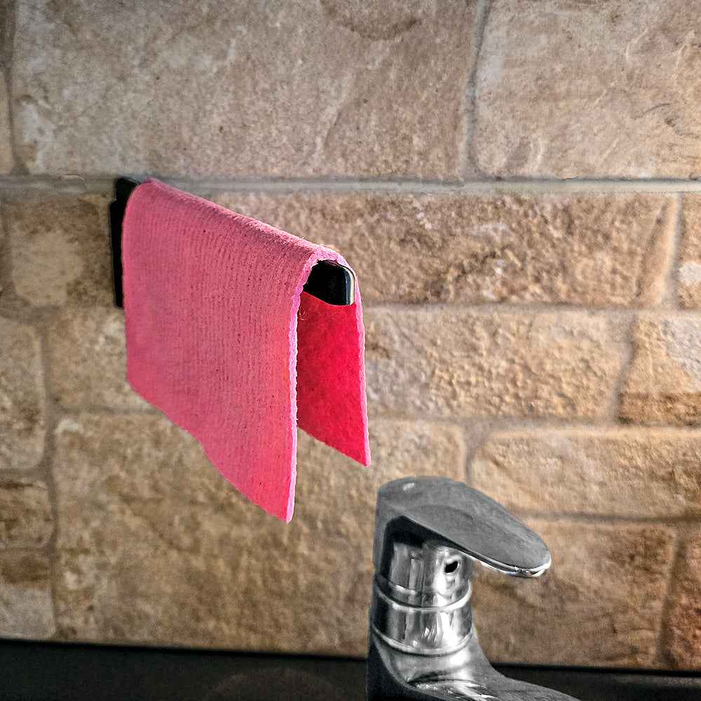 Teline tiskirätille - tiskirätin säilytysteline keittiöön, pinkki rätti roikkuu mustassa PETG-telineessä, tarrakiinnitys