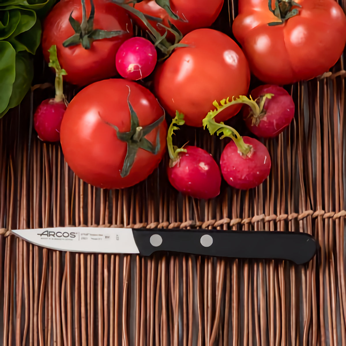 Arcos Kuorimaveitsi 7,5 cm vihannesten ja tomaattien vieressä – täydellinen pienveitsi tarkkaan kuorimiseen ja pilkkomiseen.