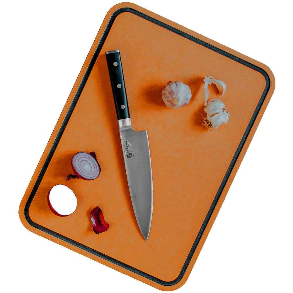 Dorre Sami leikkuulauta käytössä, veitsi ja vihanneksia laudan päällä. Kestävä ja monikäyttöinen keittiövaruste.