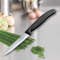 Victorinox Kuorimaveitsi 10 cm käytössä ruoanlaitossa, leikkaa ruohosipulia tarkasti ruostumattomalla terällä ja tukevalla kahvalla.