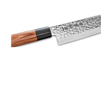 Lähikuva Kanetsune Seki kokkiveitsen Tsuchime-taotusta terästä ja puukahvasta, korostaa veitsen laadukasta viimeistelyä.