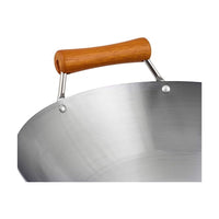 Ken Hom Hiiliteräswokin puinen apukahva ja pinnoittamaton teräspinta. Kestävä ja käytännöllinen keittiöväline.