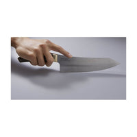 Suncraft Elegancia kokkiveitsi kädessä, korostaen sen tarkkaa SG2-terästä ja ergonomista muotoilua.